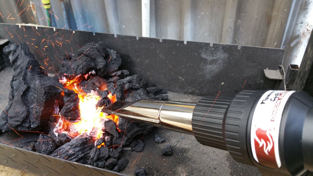 This picture shows charcoal being lit with a charcoal starter wand